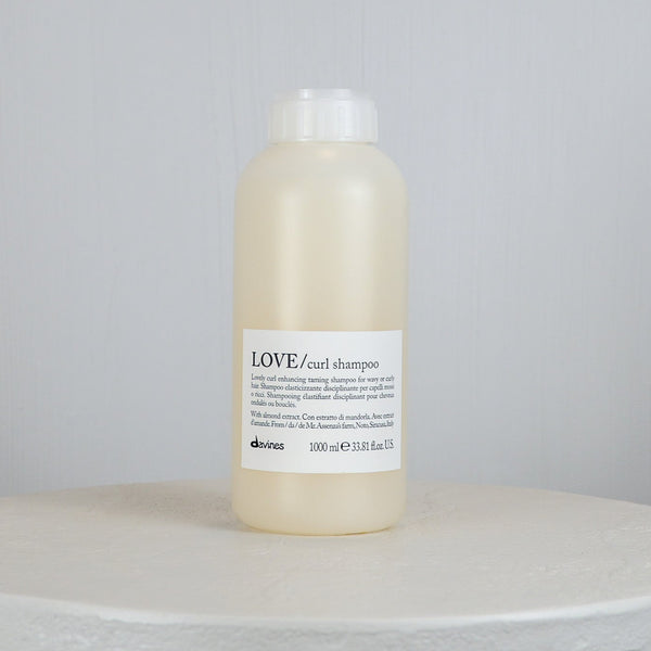 Bottle of Davines LOVE curl shampoo on a light gray background