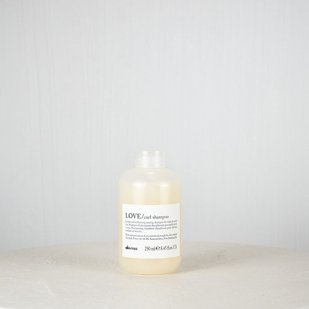 Bottle of shampoo on a white surface with a light gray background