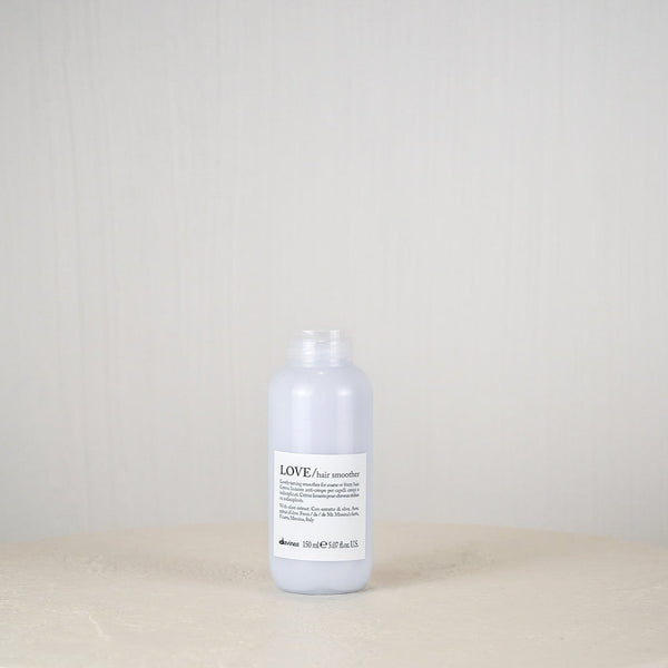 Bottle of Davines hair product on a white surface with a plain background