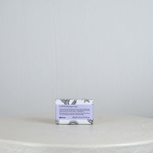 Bar of soap with a decorative label on a white surface and light gray background