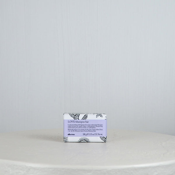 Bar of soap with a decorative label on a white surface and light gray background