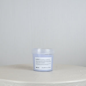 Jar of Davines LOVE conditioner on a white surface with a light gray background