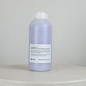 Bottle of Davines LOVE smoothing shampoo on a light gray background