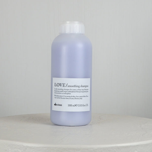 Bottle of Davines LOVE smoothing shampoo on a light gray background
