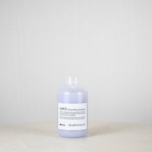 Bottle of Davines LOVE shampoo on a white surface with a light gray background