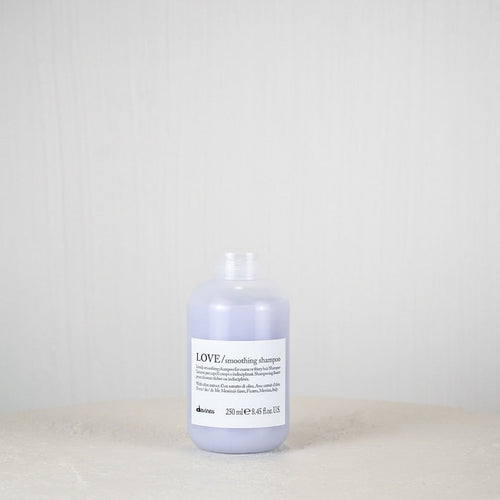 Bottle of Davines LOVE shampoo on a white surface with a light gray background