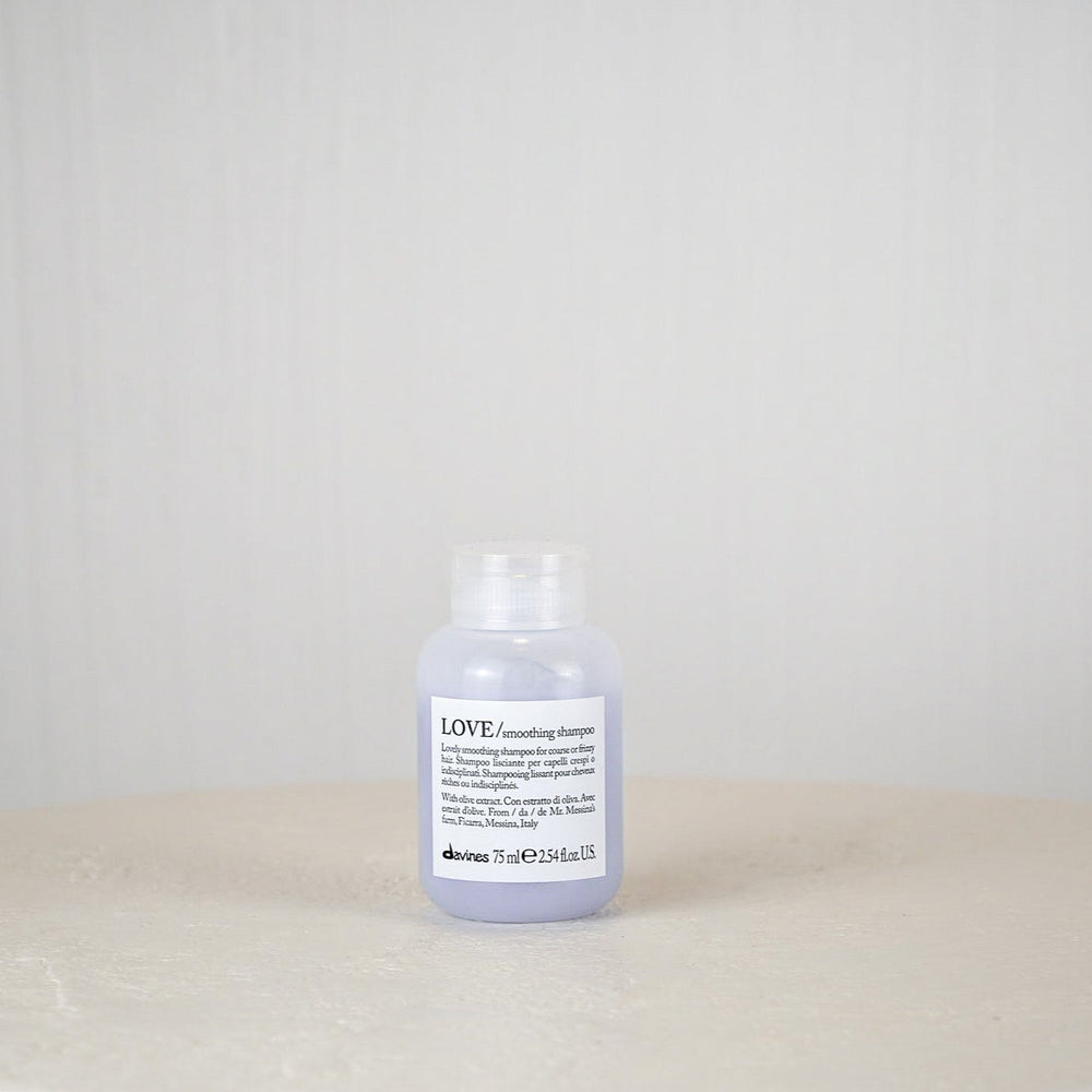 Bottle of Davines LOVE shampoo on a white surface with a light gray background
