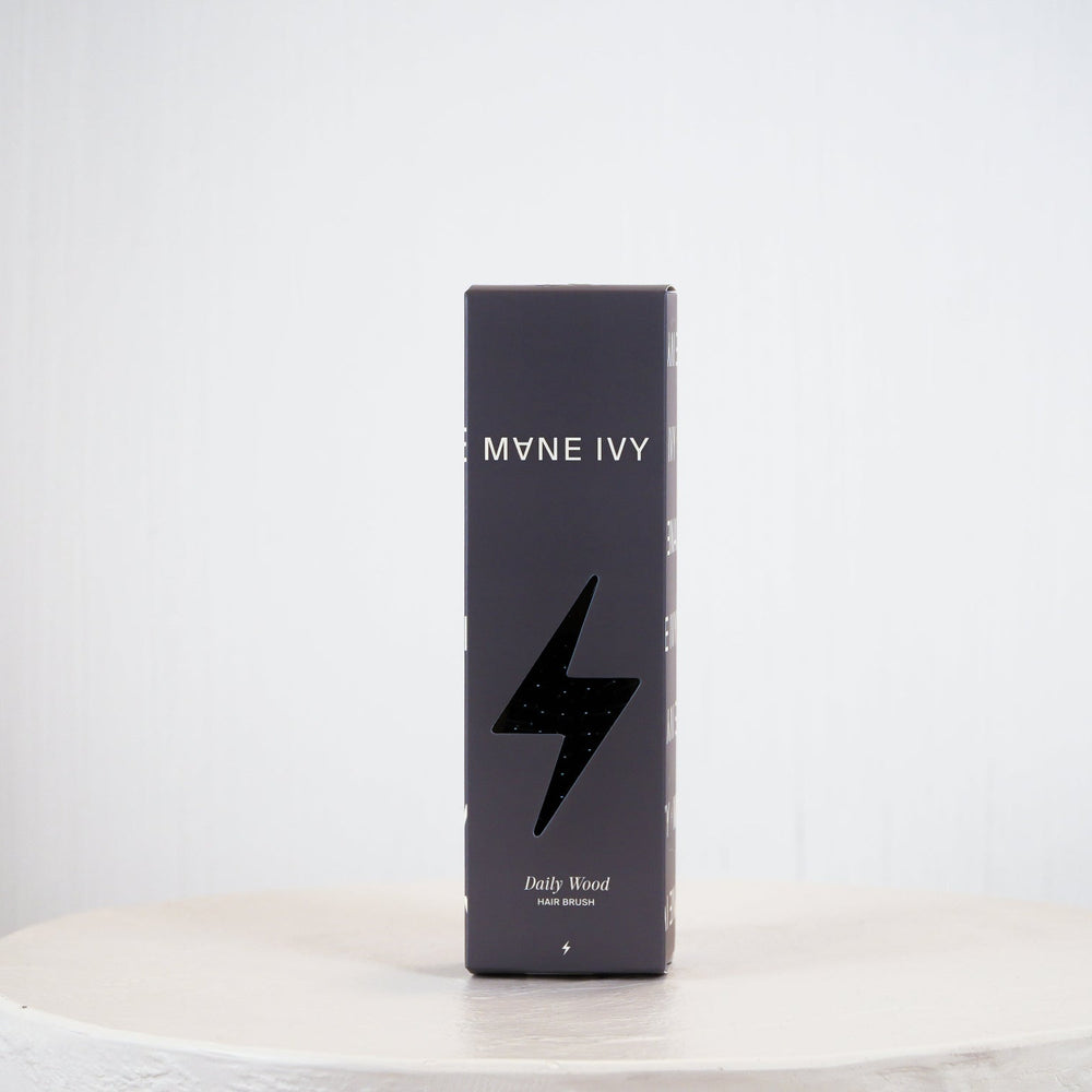 A tall, slim black rectangular box for MYNE IVY Bath Blood cologne stands upright on a round white pedestal against a light gray background.