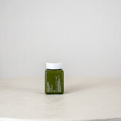 Green jar with white cap on a white surface