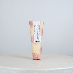 Tube of Davines hair product on a white surface with a light gray background