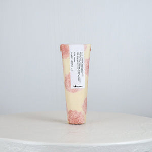 Tube of Davines hair product on a white surface with a light gray background