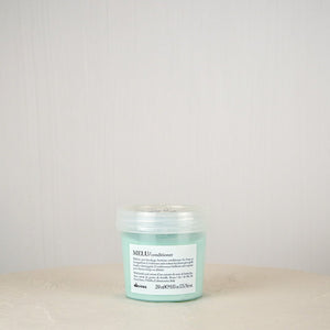 Green jar with label on a white surface against a light gray background