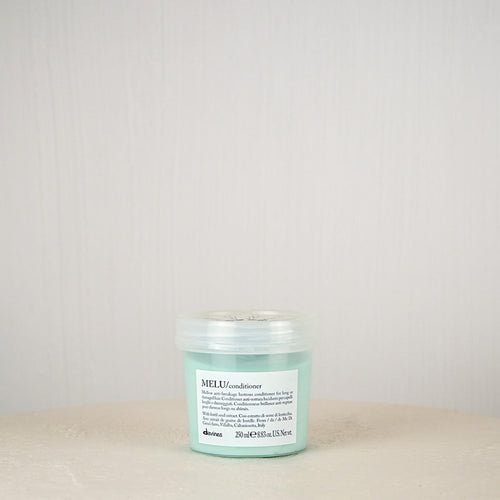 Green jar with label on a white surface against a light gray background