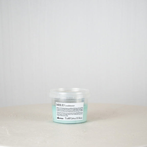 Small jar with a label on a white surface and light gray background