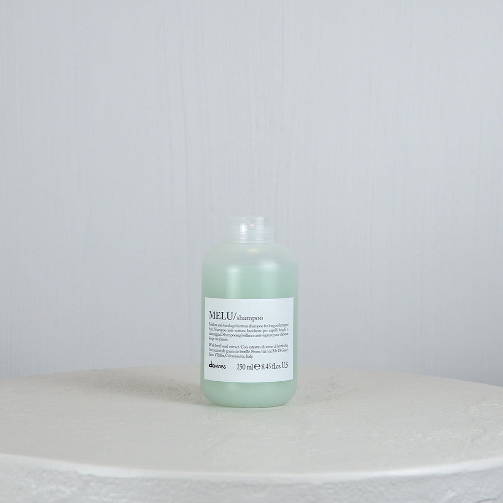 Bottle of Davines MEU shampoo on a white surface with a light gray background