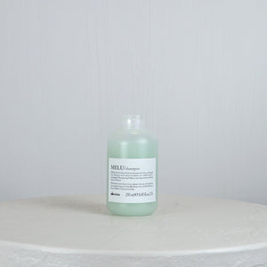 Bottle of Davines MEU shampoo on a white surface with a light gray background