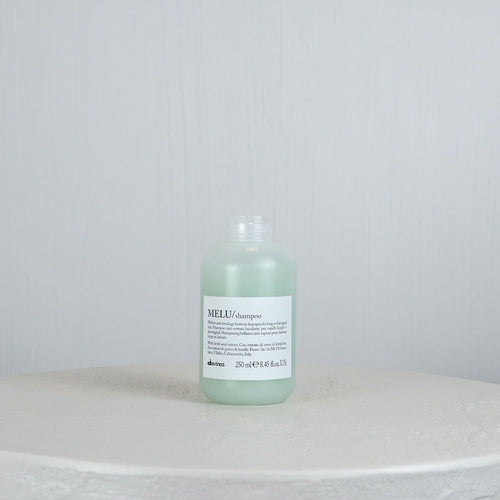 Bottle of Davines MEU shampoo on a white surface with a light gray background