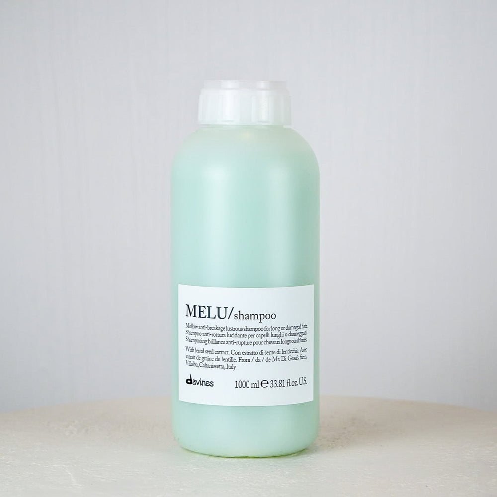 Bottle of Davines MEU shampoo on a white surface with a light gray background