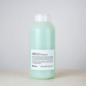 Mint green shampoo bottle with white label on a light gray background