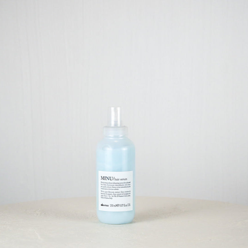 Bottle of blue liquid on a white surface with a light gray background