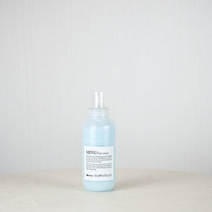 Bottle of blue liquid on a white surface with a light gray background
