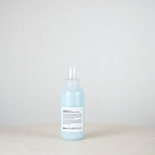 Bottle of blue liquid on a white surface with a light gray background