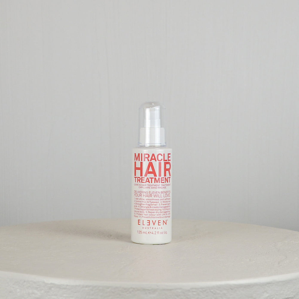 Bottle of 'Miracle Hair Treatment' by Eleven on a white surface with a light gray background