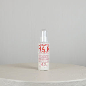 Bottle of 'Miracle Hair Treatment' by Eleven on a white surface with a light gray background
