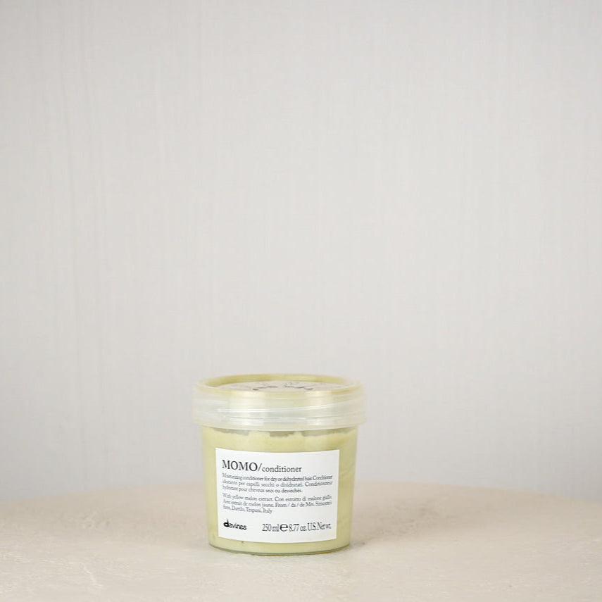Jar of Momo Conditioner on a beige surface with a light gray background
