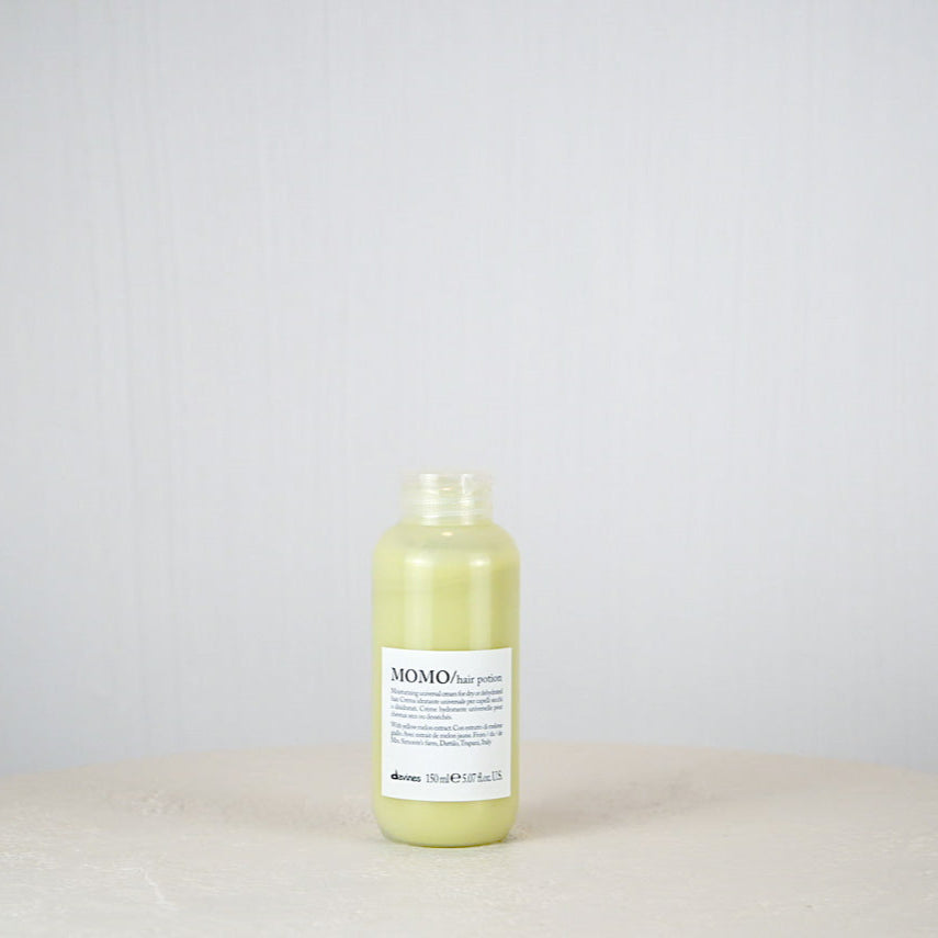 Bottle of Momo hair product on a white background