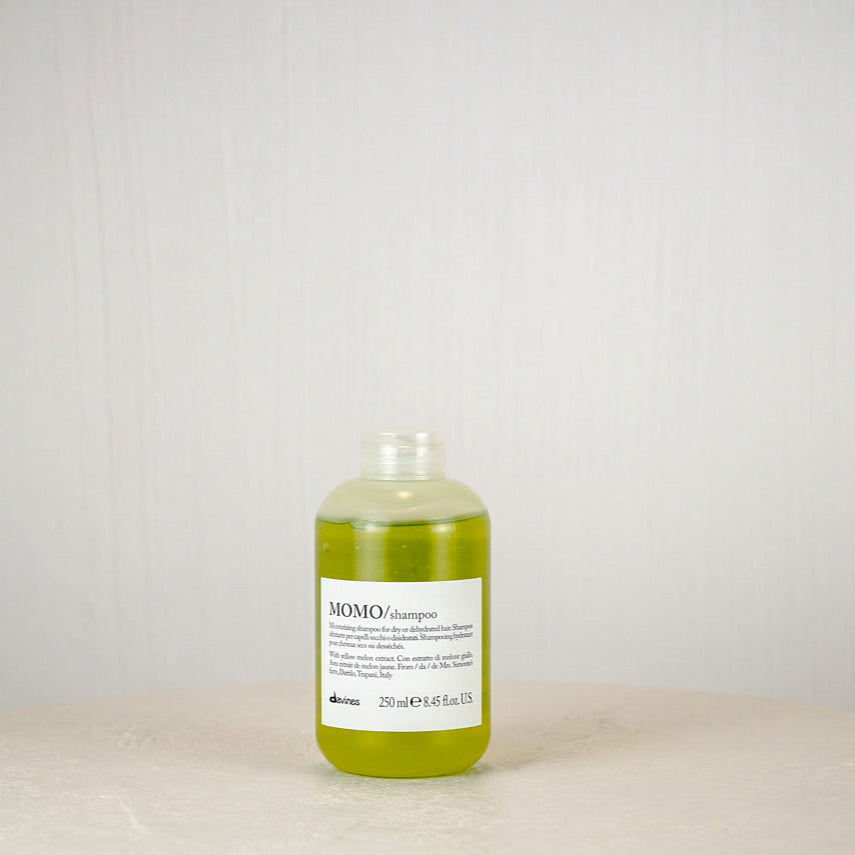 Bottle of shampoo on a white surface with a light gray background