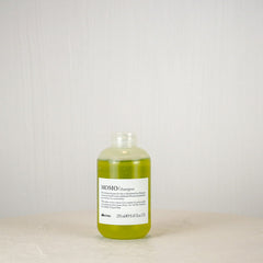 Bottle of shampoo on a white surface with a light gray background