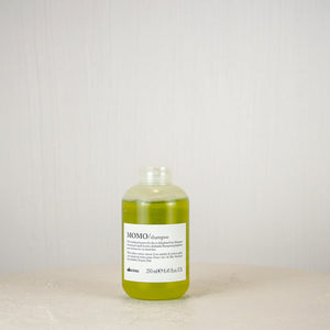 Bottle of shampoo on a white surface with a light gray background