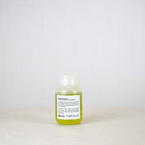 Bottle of Momo shampoo on a white background