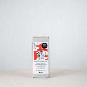 Silver package with a red label on a white surface against a light gray background