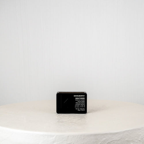 Black rectangular product on a white surface with a light gray background