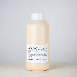 Bottle of NOUNOU conditioner on a gray background
