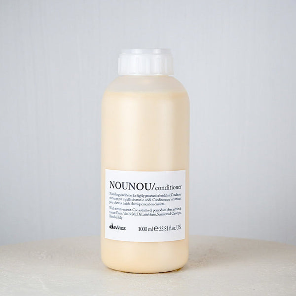 Bottle of NOUNOU conditioner on a gray background