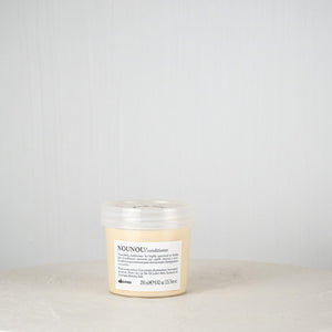Jar of Davines hair product on a white surface with a light gray background