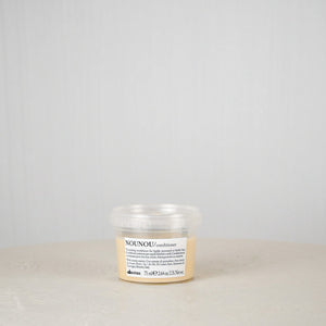 Jar of NOUNOU product on a white surface with a light gray background