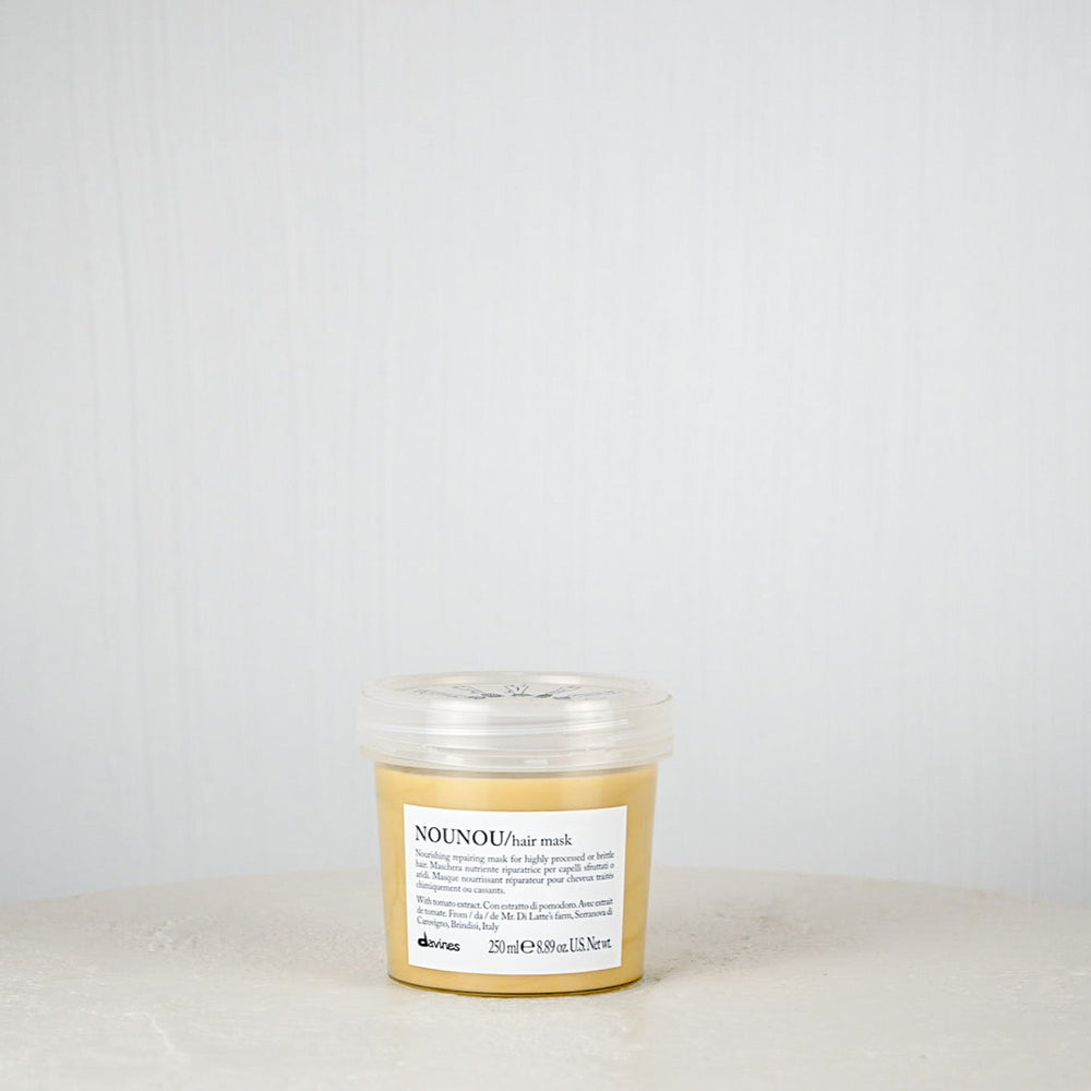 Jar of NOUNOU cream on a white surface with a white background