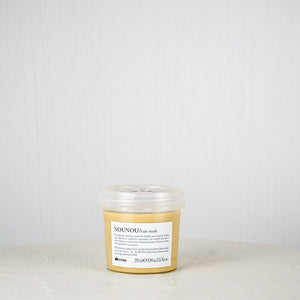 Jar of NOUNOU cream on a white surface with a white background