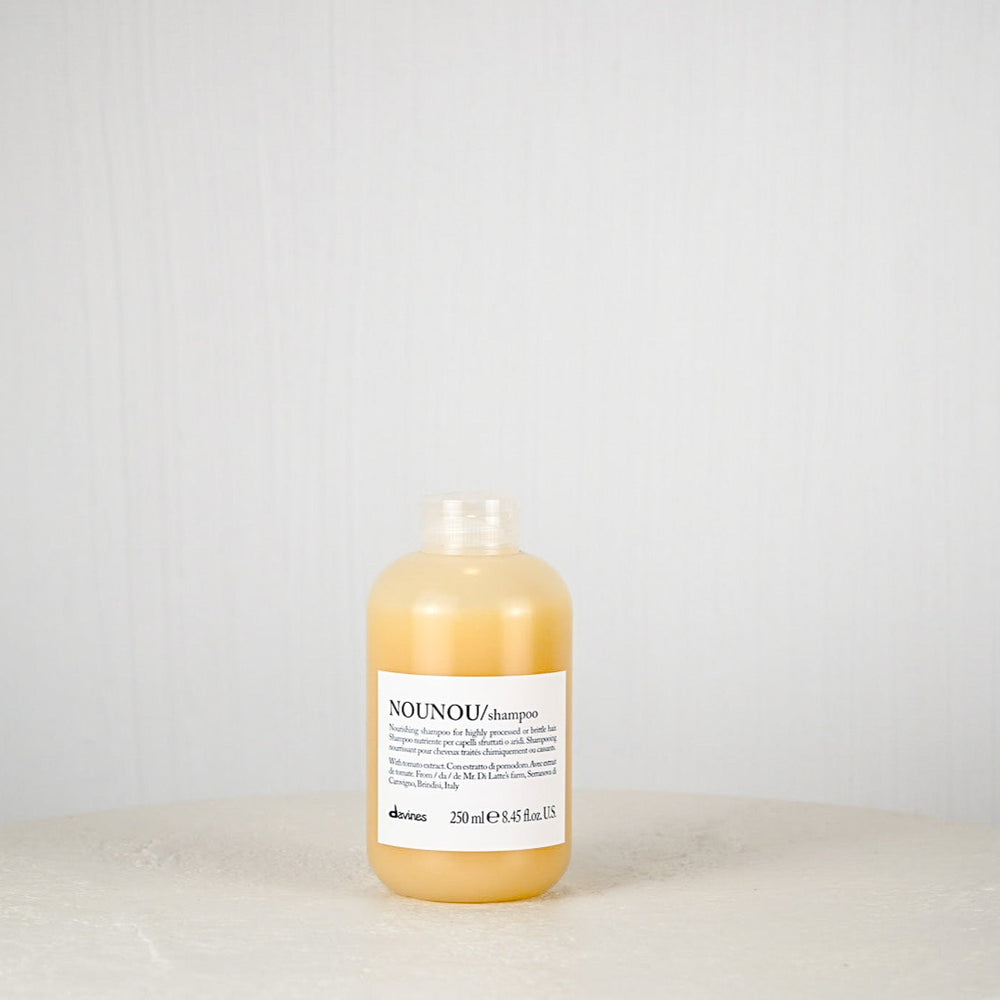 Bottle of NOUNOU shampoo on a light gray background