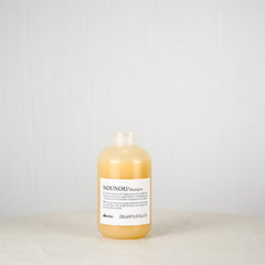 Bottle of NOUNOU shampoo on a light gray background