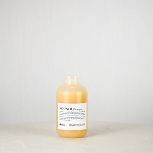 Bottle of NOUNOU shampoo on a light gray background