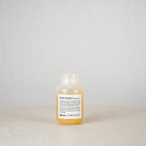 Bottle of NOUNOU shampoo on a light gray background