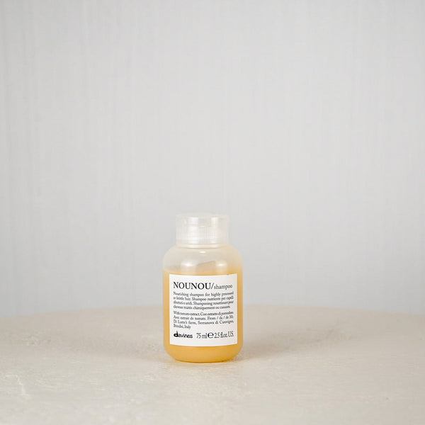 Bottle of NOUNOU shampoo on a light gray background