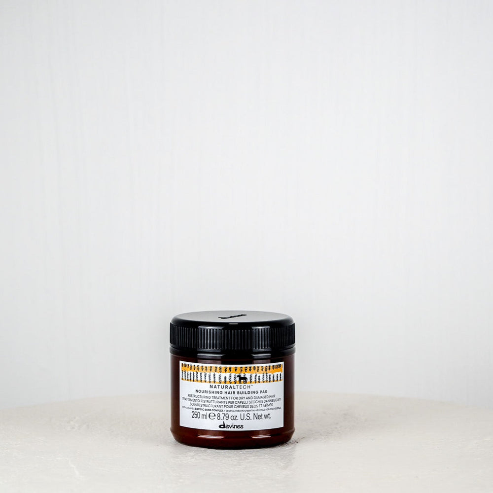 Jar of cream on a white surface with a white background