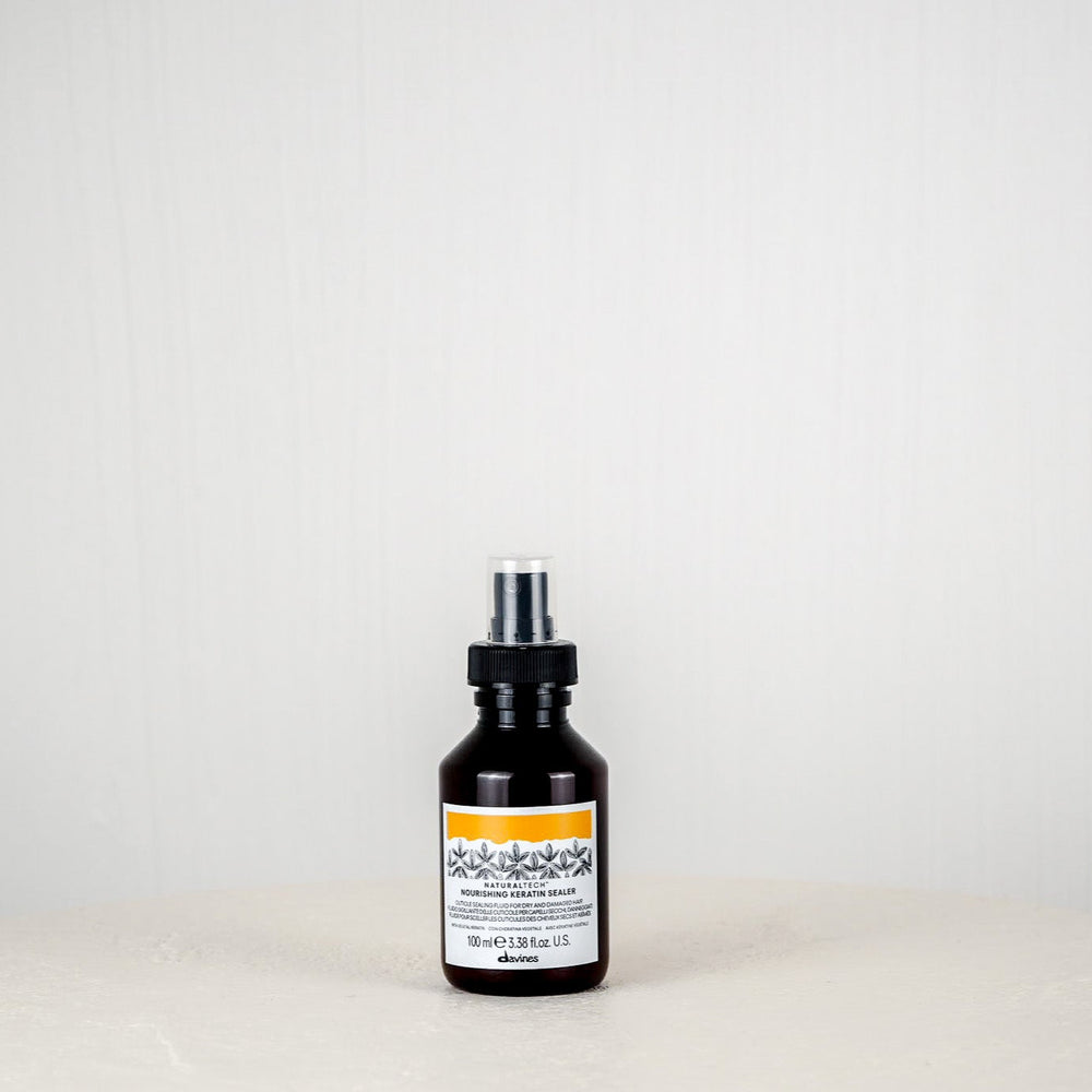 Black bottle with a label on a white surface and light gray background