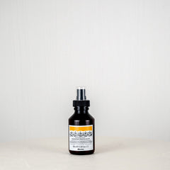 Black bottle with a label on a white surface and light gray background